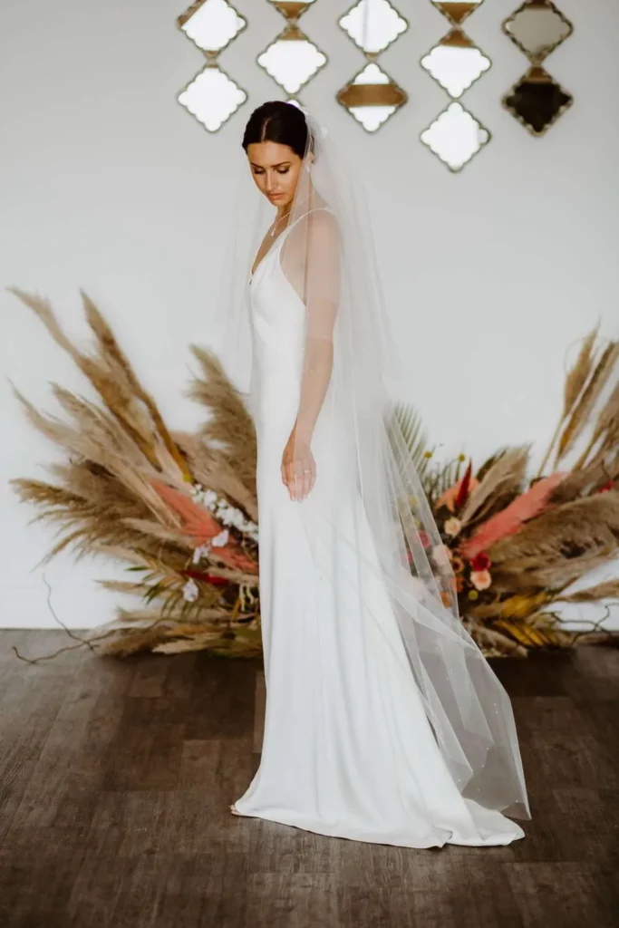 Isla-–-two-layer-floor-length-veil-with-a-cut-edge-scattered-pearls-walking-3-683x1024